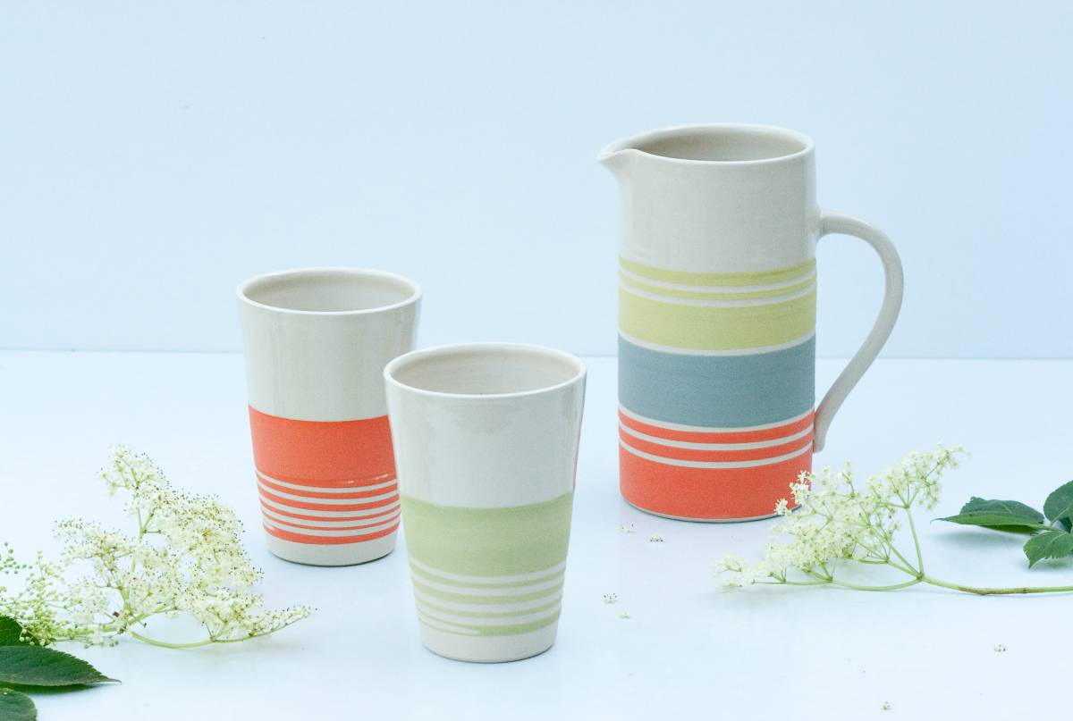 Tall jug and conical beakers with stripes in bright slip colours