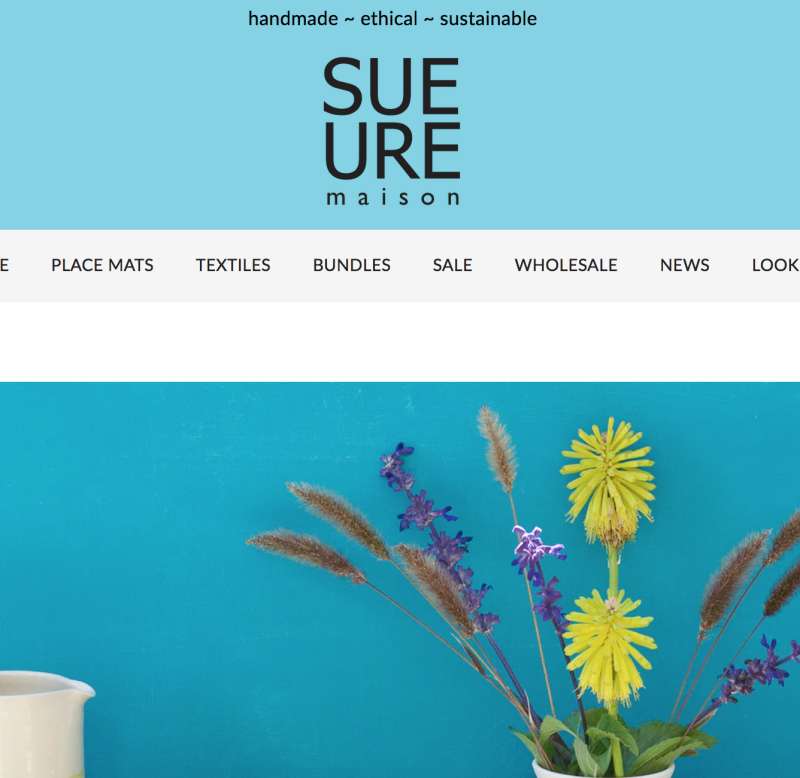 Capture of part of the Sue Ure Maison home page with a breakfast service on a blue background.